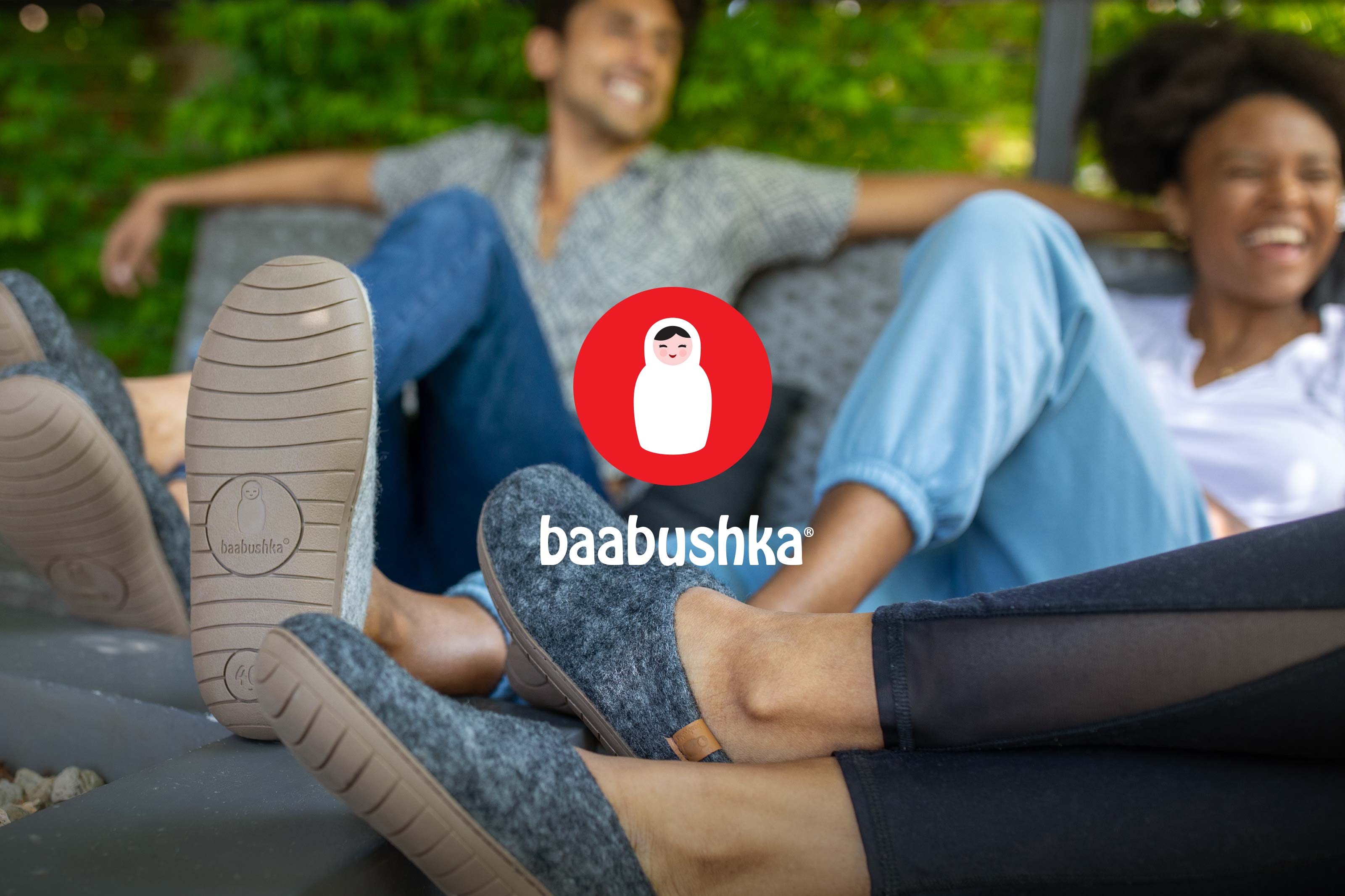 Several attractive people wearing Baabushka wool slippers with rubber soles, sitting outdoors and enjoying the company of their friends.